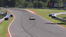 a white sports car is driving on a track