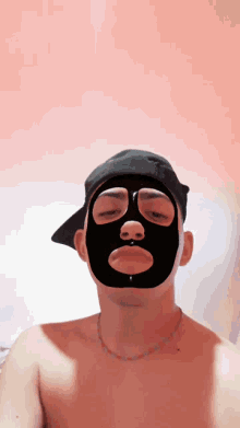 a shirtless man wearing a black mask and a hat