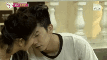 a man and a woman are kissing each other on the forehead .