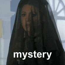 a woman with a black veil on her head and the word mystery below her