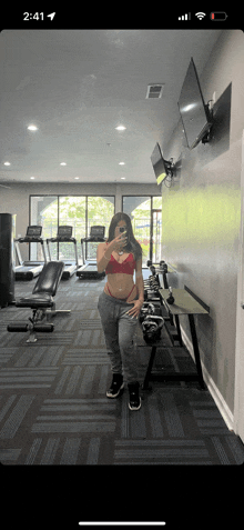 a woman taking a picture of herself in a gym with the time 2:41