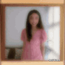 a blurry picture of a woman in a pink shirt with the word mayward on the bottom