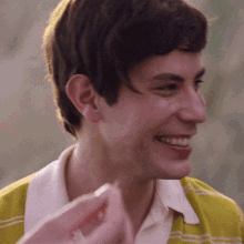 a close up of a man 's face with a yellow shirt