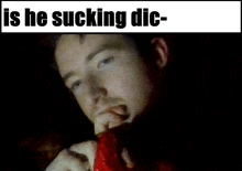 a picture of a man eating a red object with the caption is he sucking die-