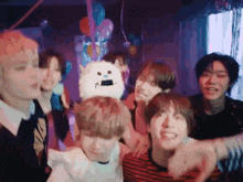 a group of young men are posing for a picture at a party with balloons .