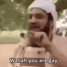 a man with a beard and a white hat says wallah you are gay