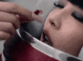 a close up of a woman 's face with red nails