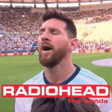 a man with a beard is standing on a soccer field with his eyes closed .