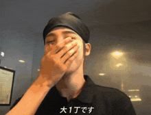 a person covering their face with their hand with chinese writing on the bottom