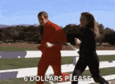 a man and a woman are running on a track and the man is wearing a red suit and the woman is wearing black pants .
