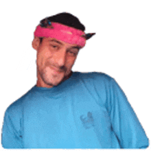 a man wearing a blue shirt and a pink bandana on his head .
