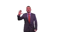 a man in a purple suit and red tie is waving