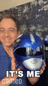 a man holding a blue power ranger helmet that says it 's me