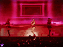 a woman in a red outfit is singing into a microphone on stage