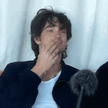 a man with a ring on his finger is covering his mouth with his hand