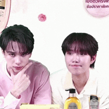 two men standing next to each other with a bottle of pantene in front of them