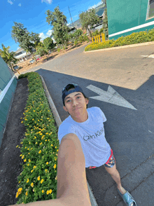 a young man wearing a white calvin klein t-shirt takes a selfie