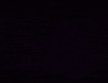 a man 's face is shown in the dark with a blurry background of lights