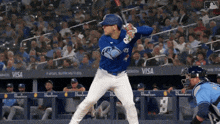 a baseball player in a blue jays uniform is about to swing his bat