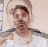 a man with a beard is wearing headphones and smoking a cigarette in front of a wall .