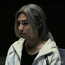 a man with long gray hair is wearing a netflix hoodie