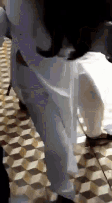 a person in white pants is standing on a tiled floor