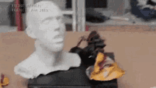 a statue of a man 's head is sitting on a table next to a pile of chips .