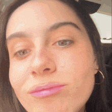 a close up of a woman 's face with pink lips and hoop earrings