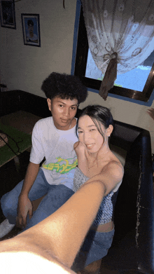a man and a woman are posing for a picture and the man is wearing a shirt that says ' a '