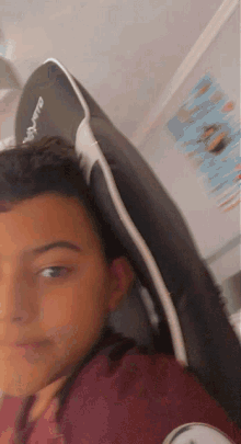 a blurry picture of a young boy sitting in a chair with a black and white headrest