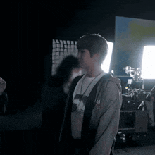 a young man wearing a t-shirt that says ' no ' on it stands in a dark room