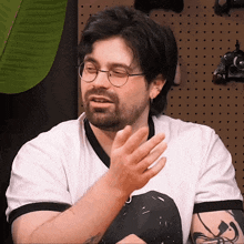 a man wearing glasses and a white shirt is talking