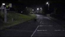 a person is riding a bike down a street and giving the middle finger .