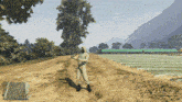 a video game character is standing on a dirt road in a field