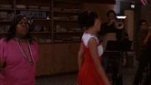 two women are dancing in front of a white board with duets written on it