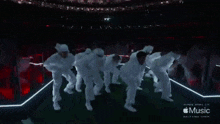 a group of people are dancing on a stage with the word music on the bottom