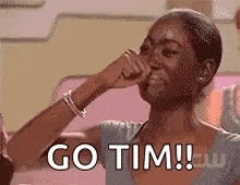 a woman is covering her nose with her hand and saying `` go tim ! ''