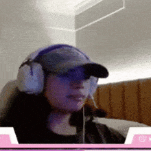 a woman wearing headphones and a hat is sitting in a chair