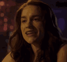 a close up of a woman 's face in a dark room .