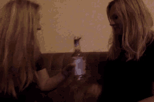 a woman holding a bottle with a blue label