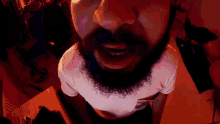 a man with a beard and mustache is wearing a white shirt with a red background