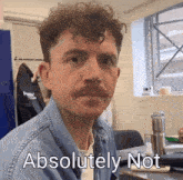 a man with curly hair and a mustache has the words " absolutely not " written on his face