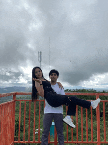 a man is carrying a woman in his arms while they pose for a photo