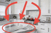 a kitchen with two red arrows pointing to a fork on a counter
