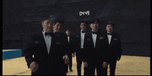 a group of men in tuxedos are standing in front of a digital clock that reads 0449