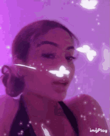 a woman with butterflies on her face is standing in front of a purple wall .
