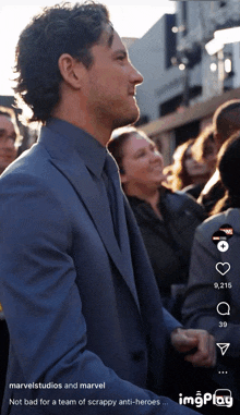 a man in a suit is standing in front of a crowd of people