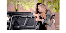two women are hugging each other in the back of a truck .