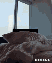 a bed with white sheets and pillows and the name judleklek702 on the bottom