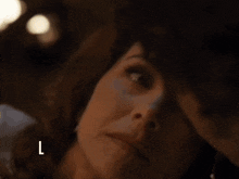 a close up of a woman 's face with the letter l below her